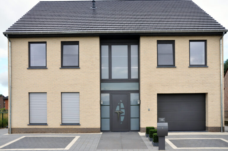 Woning met voordeur en zijlichten, ramen en rolluiken in een lichte gevel