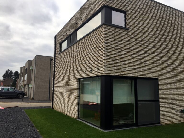 Aluminium hoekramen met grote glaspartij in een moderne bakstenen woning