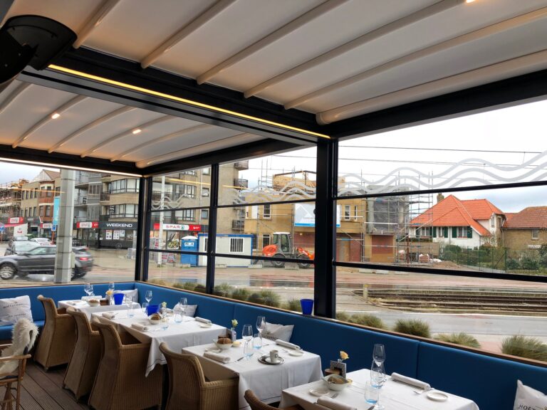 Pergola met vouwdak en verlichting boven een terras met gedekte tafels