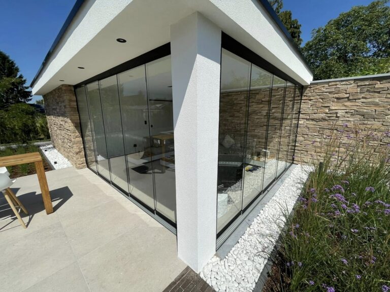 Poolhouse met glazen schuifwanden op de hoek en natuurstenen muren