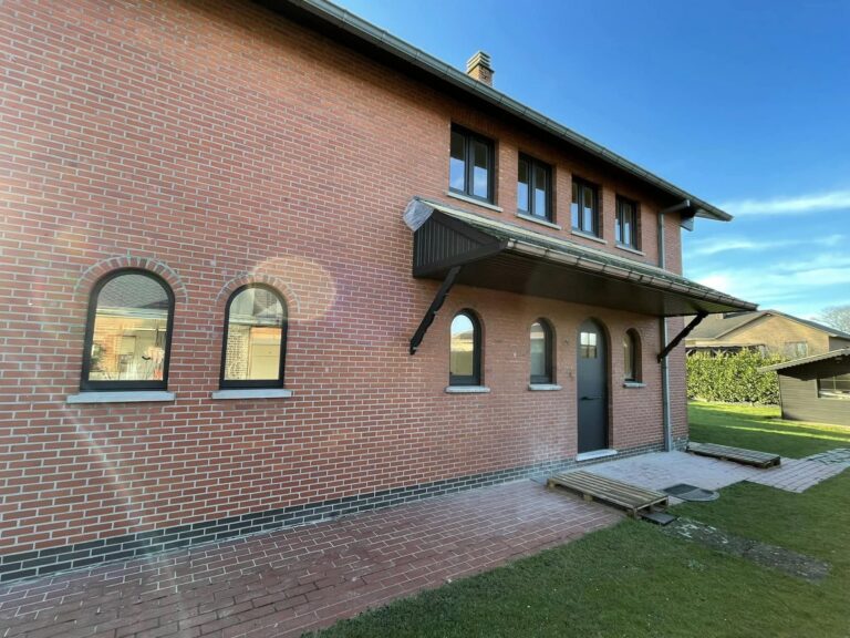 Bakstenen woning in Oudsbergen met gebogen PVC ramen